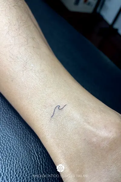 minimalist-fine-line-tattoo-surf-wave-ankle-men