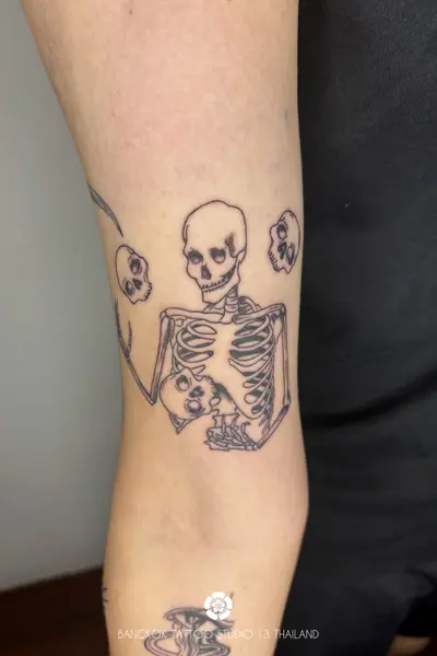 weird-tattoo-skeleton-juggles-with-head-skulls